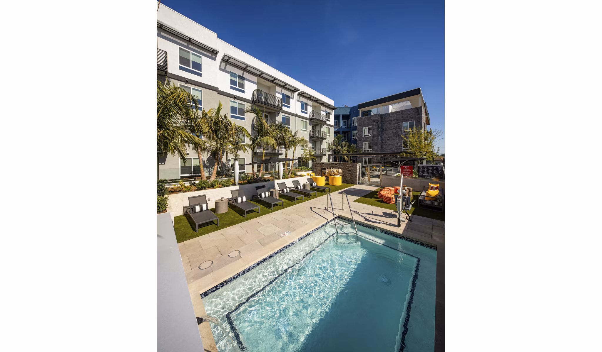Modern outdoor pool area with lounge chairs at Garrison Apartments, Greystar luxury apartments, offering leisure and relaxation