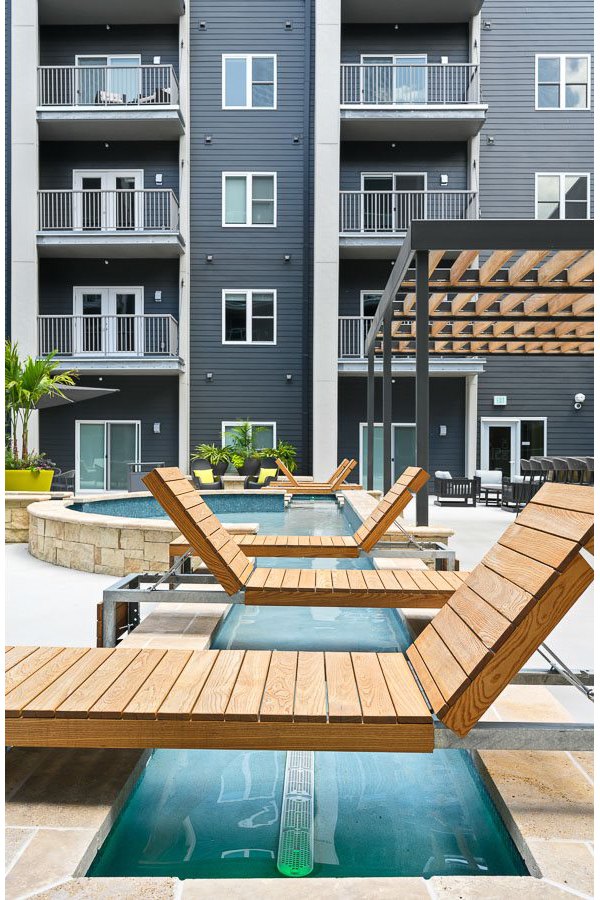 Modern outdoor pool with sun loungers at Brookside 51 Apartments, offering relaxation and recreation options within a premier community