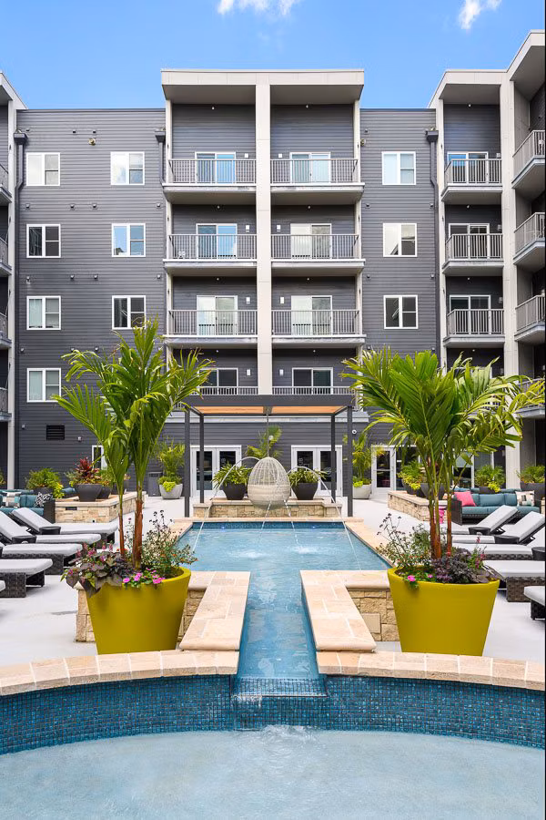 Refreshing outdoor pool at Brookside 51 Apartments offering a relaxing oasis with sun loungers and greenery