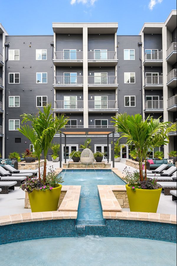 Refreshing outdoor pool at Brookside 51 Apartments offering a relaxing oasis with sun loungers and greenery