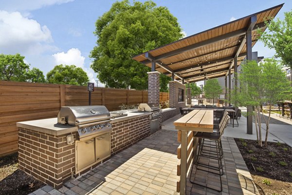 Outdoor grill area at The Jameson at the Bluffs Apartments, featuring modern barbeque stations and seating for residents