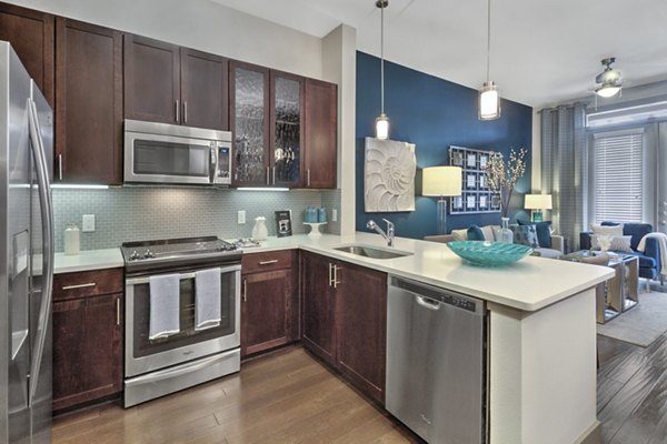 Modern kitchen with stainless steel appliances in Circuit Apartments