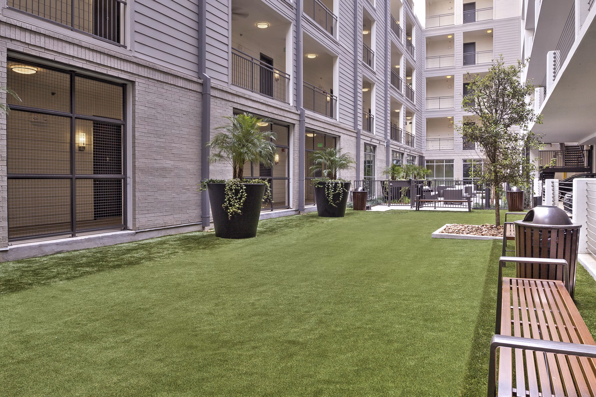 Circuit Apartments: Tranquil courtyard with lush greenery and seating areas, perfect for relaxation in the heart of the city