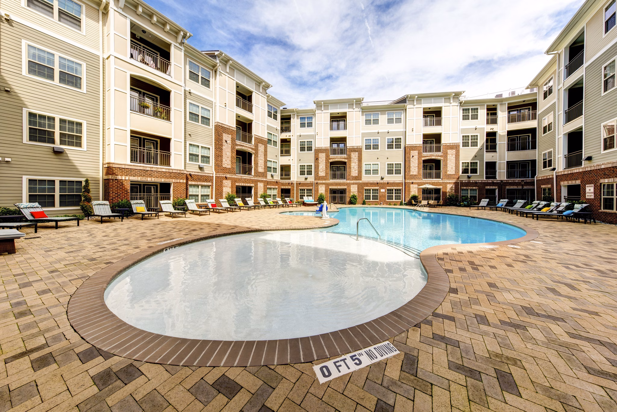 Outdoor pool with lounge chairs at The Manor at Weston Apartments