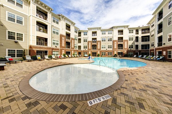 Outdoor pool with lounge chairs at The Manor at Weston Apartments