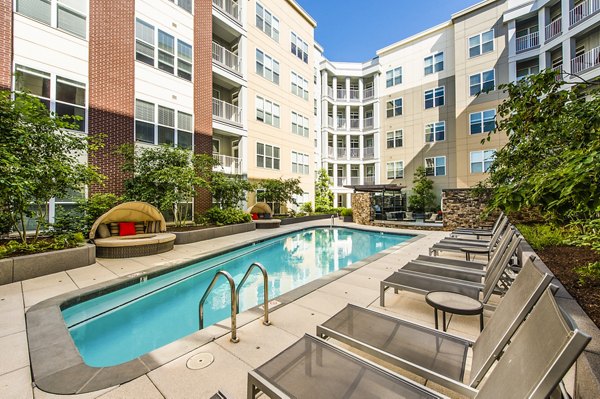 Resort-style pool at Pike3400 Apartments in luxury setting with lounge chairs and greenery