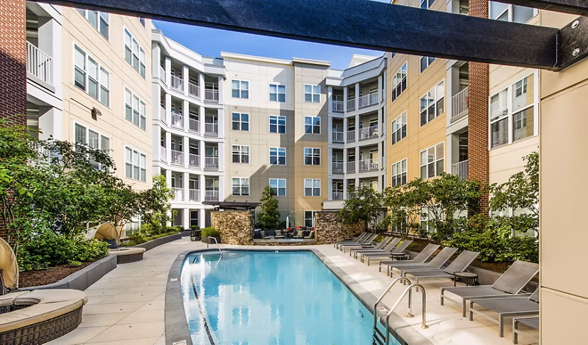Luxury pool at Pike3400 Apartments with lounge chairs and cityscape views