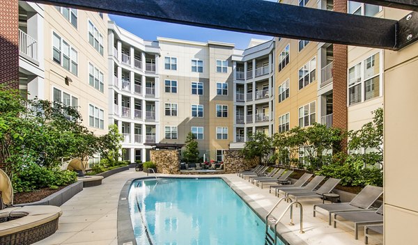 Luxury pool at Pike3400 Apartments with lounge chairs and cityscape views