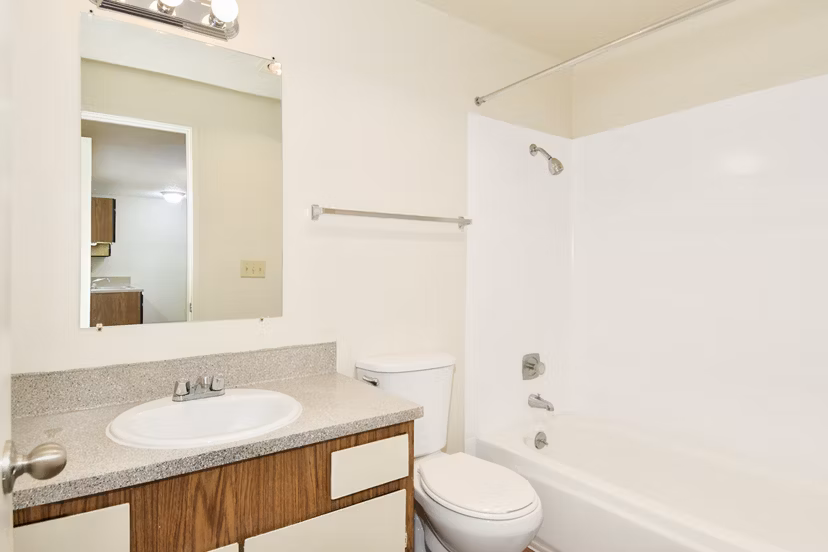 Modern bathroom with sleek fixtures and large mirror at Lake Crest Apartments