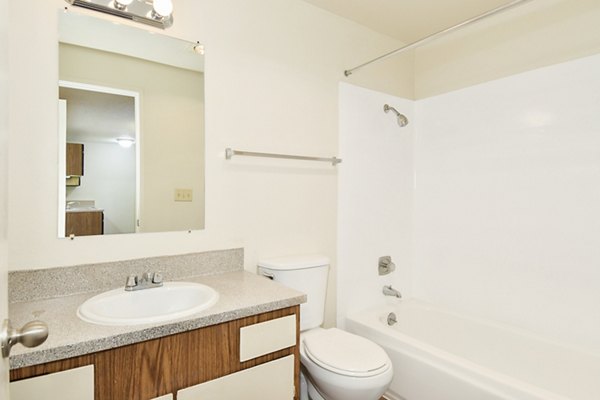 Modern bathroom with sleek fixtures and large mirror at Lake Crest Apartments