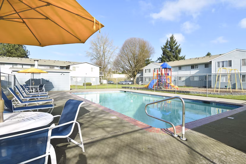 Outdoor swimming pool at Lake Crest Apartments featuring luxury lounging areas