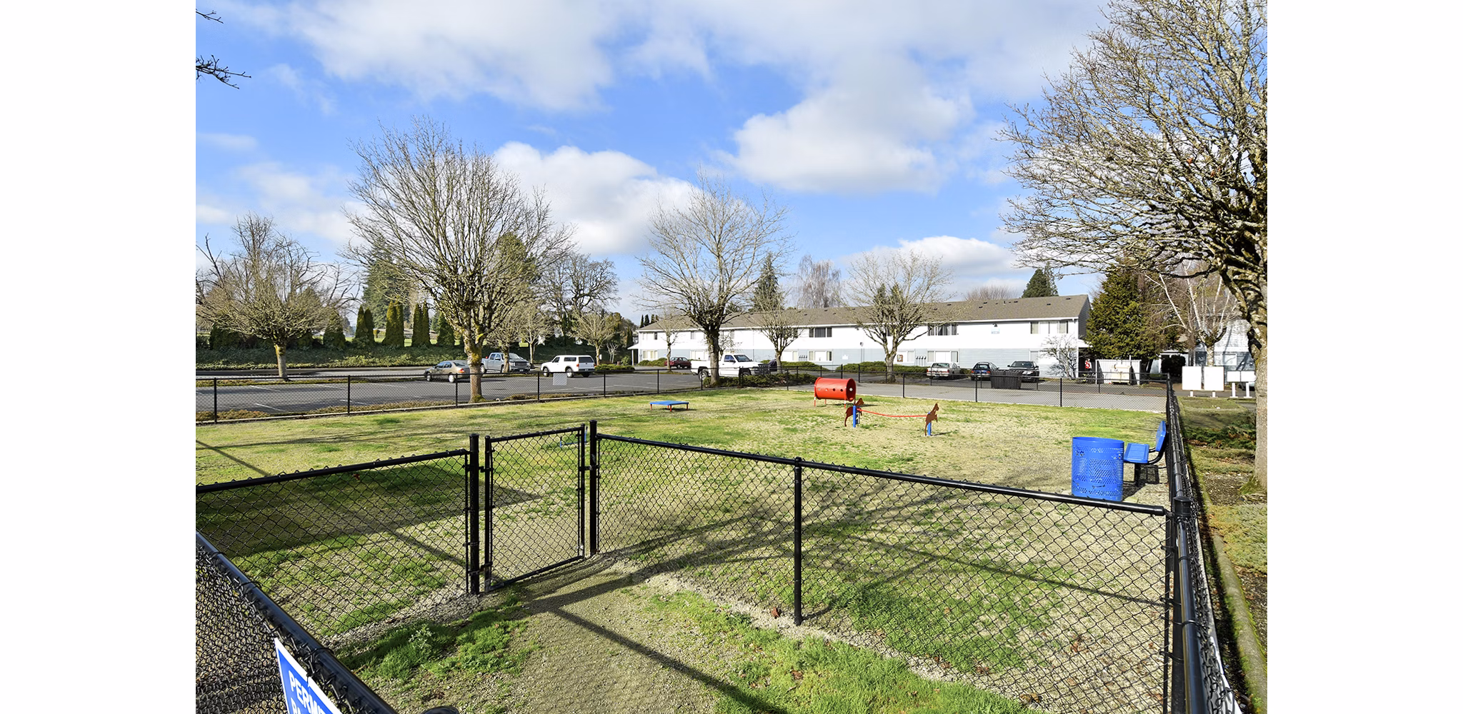 Spacious dog park with agility equipment at Lake Crest Apartments, perfect for pet-friendly living in a Greystar community