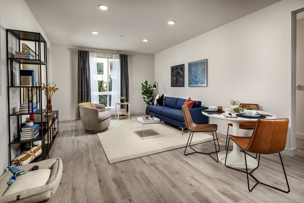 Living room featuring modern furnishings and large windows at Cameo Apartments