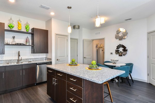 Kitchen with modern appliances and sleek cabinetry in Isla Apartments