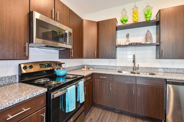Contemporary kitchen with stainless steel appliances at Isla Apartments