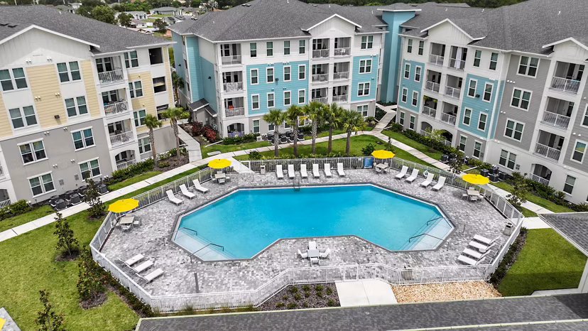 Isla Apartments: Luxury pool with lounge chairs and lush landscaping