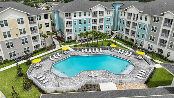 Isla Apartments: Luxury pool with lounge chairs and lush landscaping
