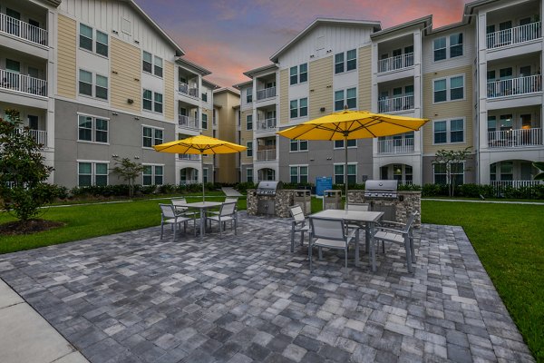 Outdoor grill area with modern seating at Isla Apartments