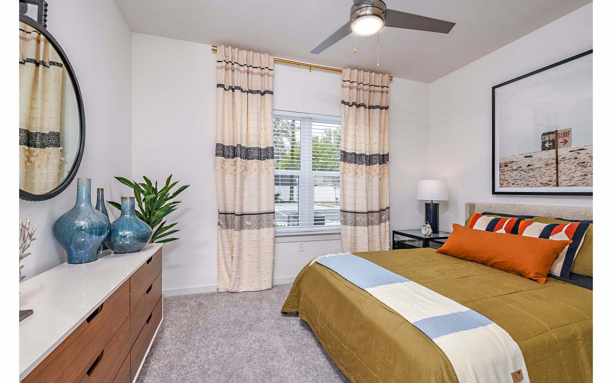 Modern bedroom with plush bedding at Renaissance Santa Rosa Apartments, featuring large windows and elegant decor