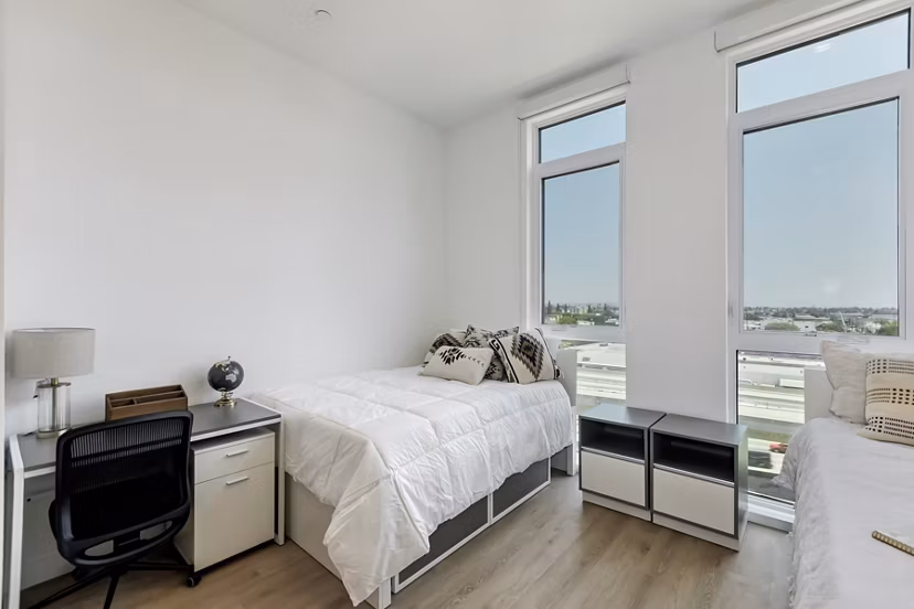 The 505 Apartments: Elegant bedroom featuring plush bedding and modern decor in downtown luxury setting
