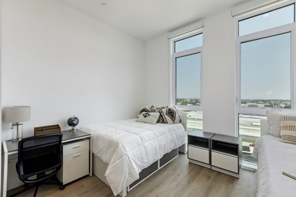 The 505 Apartments: Elegant bedroom featuring plush bedding and modern decor in downtown luxury setting