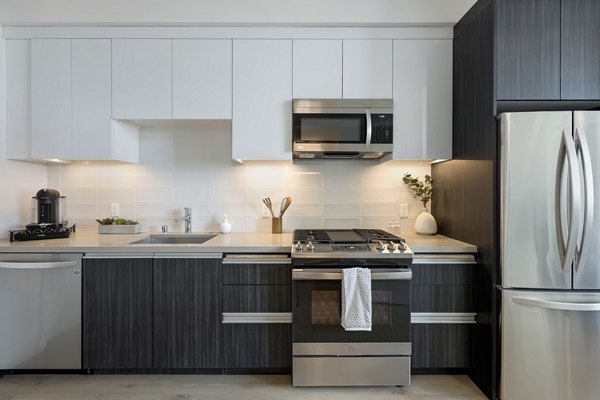 Modern kitchen featuring stainless steel appliances and island counter at The 505 Apartments