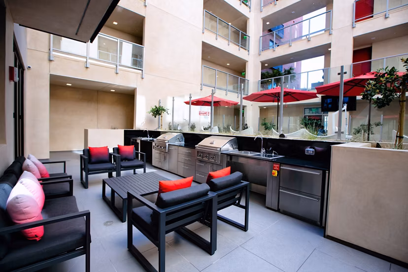 Modern outdoor grill area at The 505 Apartments with seating and lighting, perfect for social gatherings and alfresco dining
