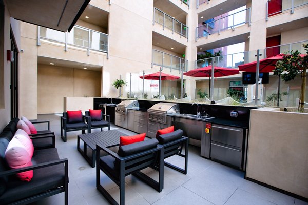 Modern outdoor grill area at The 505 Apartments with seating and lighting, perfect for social gatherings and alfresco dining