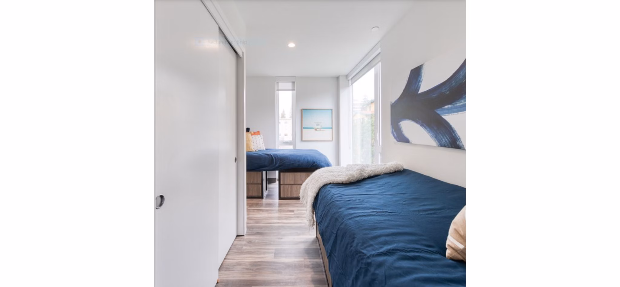 Modern bedroom with plush bedding and ample natural light at The Durant Apartments