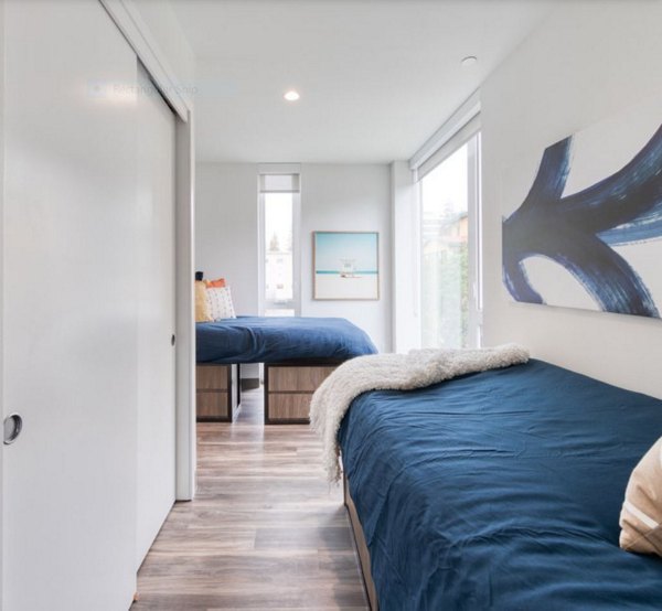 Modern bedroom with plush bedding and ample natural light at The Durant Apartments