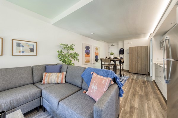 Spacious living room with modern decor and natural light at The Durant Apartments