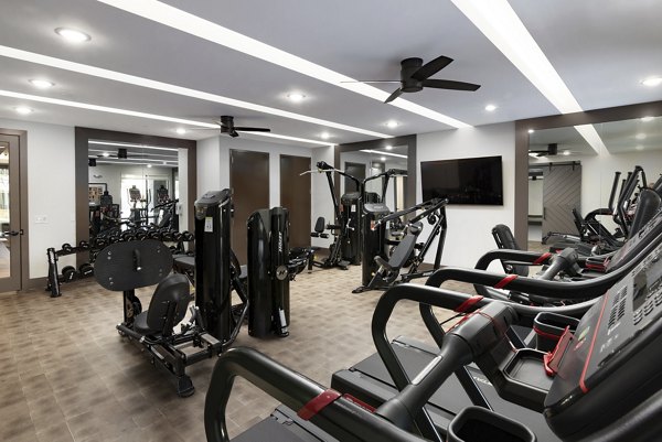 Modern fitness center equipped with weights and cardio machines at Everleigh Duluth Apartments