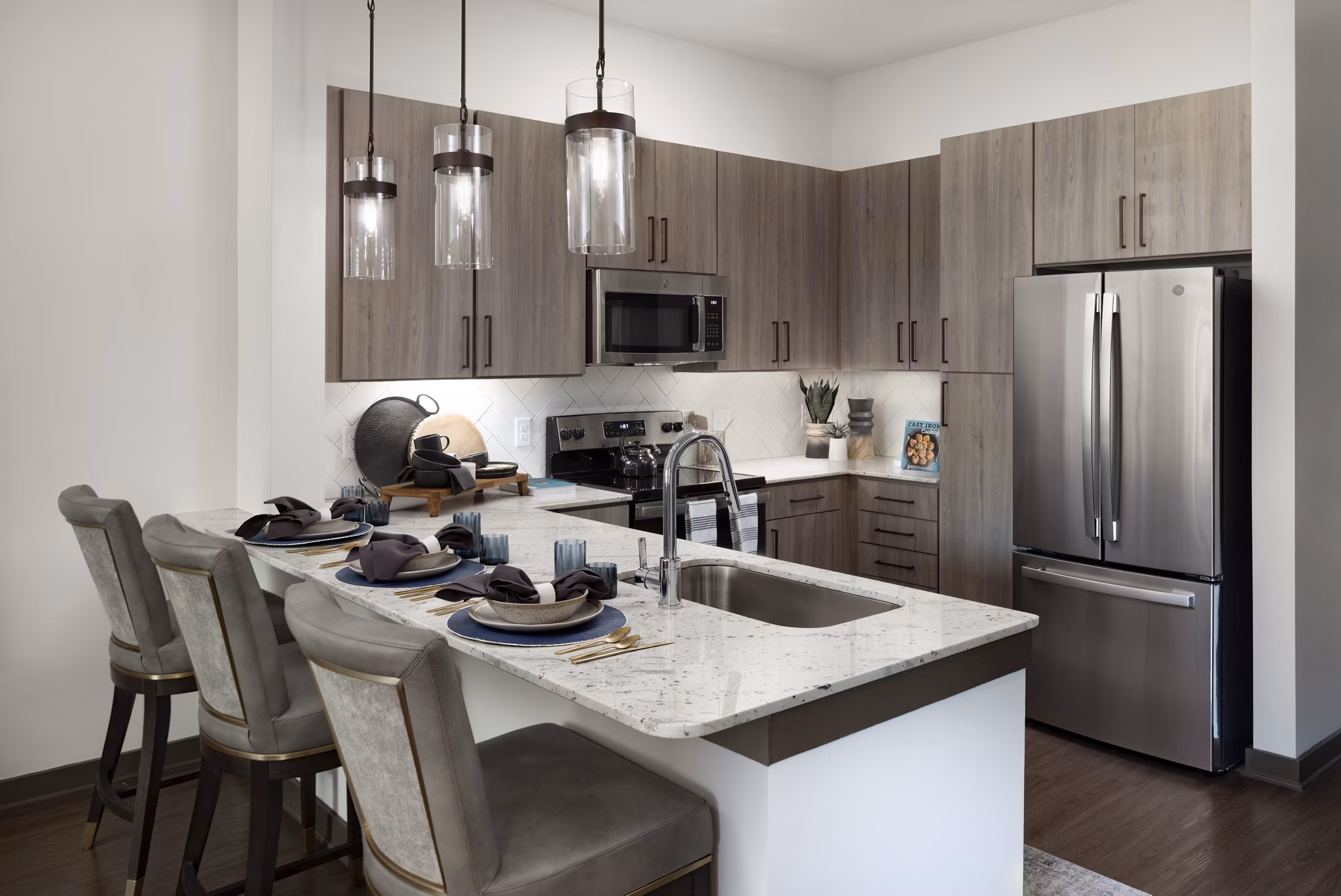 Modern kitchen with stainless steel appliances and granite countertops at Everleigh Duluth Apartments