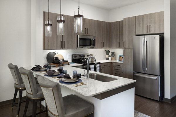 Modern kitchen with stainless steel appliances and granite countertops at Everleigh Duluth Apartments