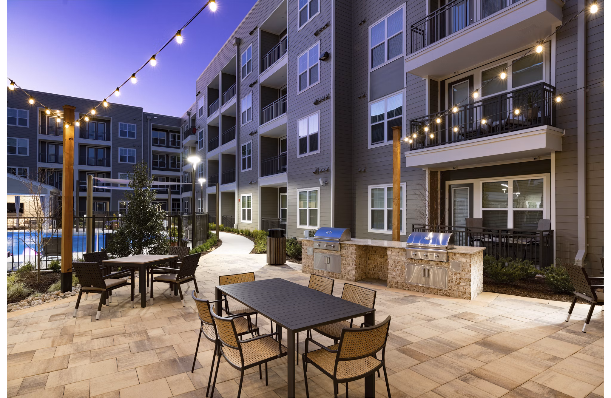 Outdoor grill area with modern seating and lush landscaping at Everleigh Duluth Apartments Perfect for gatherings and leisure activities