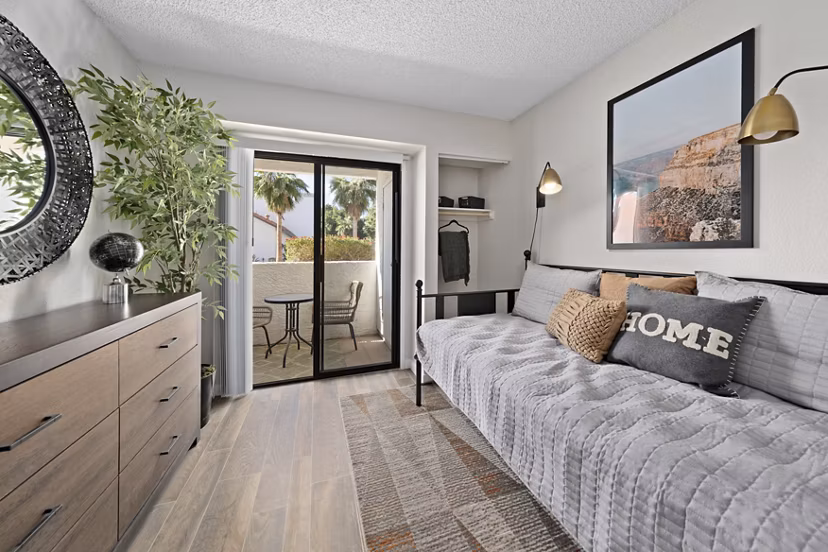 Bedroom with modern decor and large window at Solas Glendale Apartments, offering luxury living in a serene environment