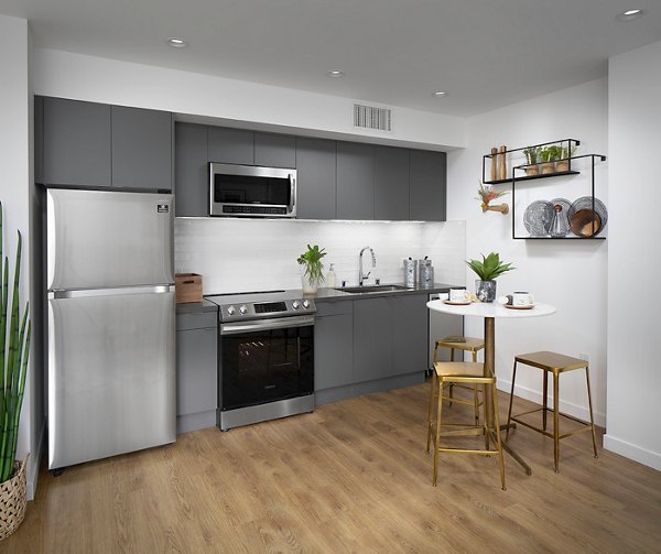 Kitchen featuring modern appliances and a sleek island at Cielo Apartments, luxury living in a prime location