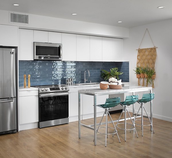 Cielo Apartments: Modern kitchen featuring stainless steel appliances and quartz countertops in luxury Greystar apartments