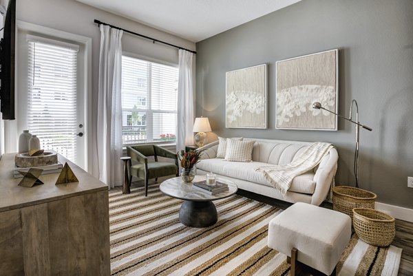 Spacious living room with modern decor and large windows in Prime Apartments, offering comfort and style in urban living
