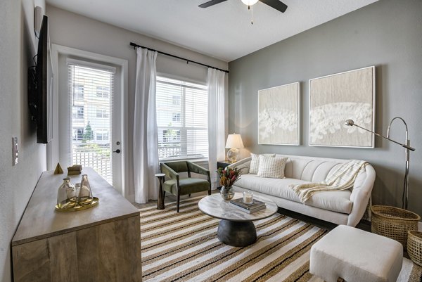 Inviting living room featuring modern furniture and large windows at Prime Apartments