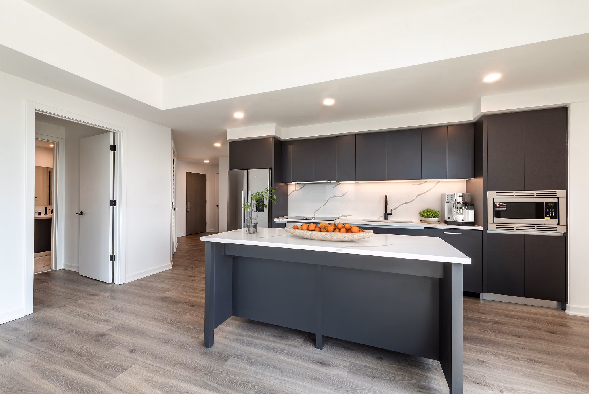 Modern kitchen with stainless steel appliances and quartz countertops in The Gantry Apartments