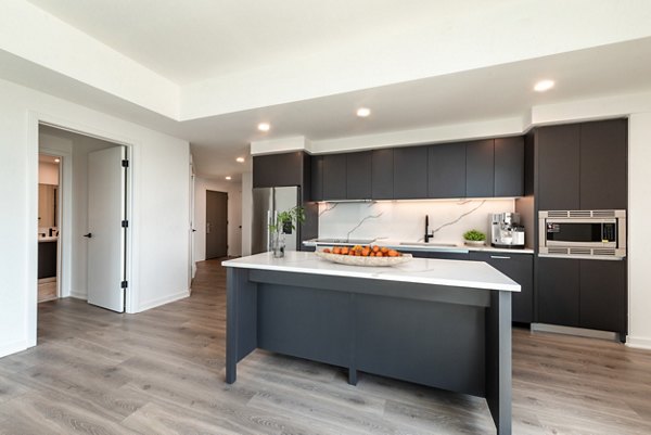 Modern kitchen with stainless steel appliances and quartz countertops in The Gantry Apartments
