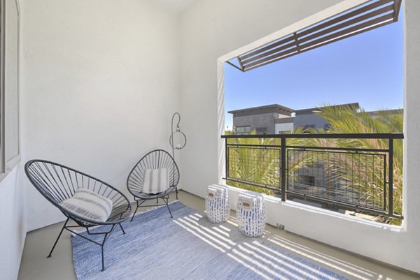 Modern outdoor patio space with stylish seating and vibrant greenery at Persea Apartments