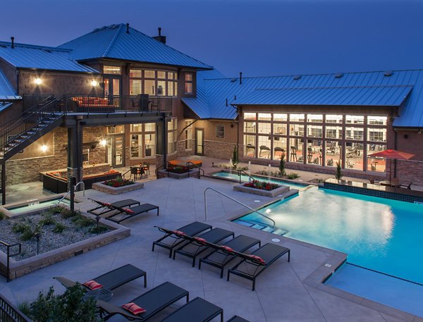 Modern outdoor pool with lounge chairs at Arvada Station Apartments offering a relaxing retreat for residents