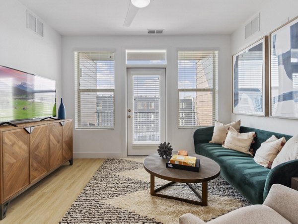 Modern living room with elegant decor in Upper West Apartments featuring cozy seating and ample natural light