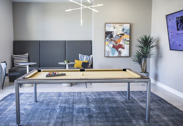 Modern game room featuring a pool table and lounge seating at Mirella at Foxboro Apartments