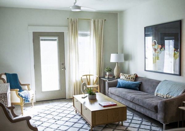 Modern living room with natural light at Mirella at Foxboro Apartments Cozy furnishings enhance luxury apartment living