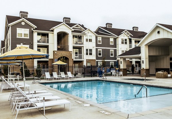 Resort-style pool area with lounge chairs at Mirella at Foxboro Apartments, offering luxury living