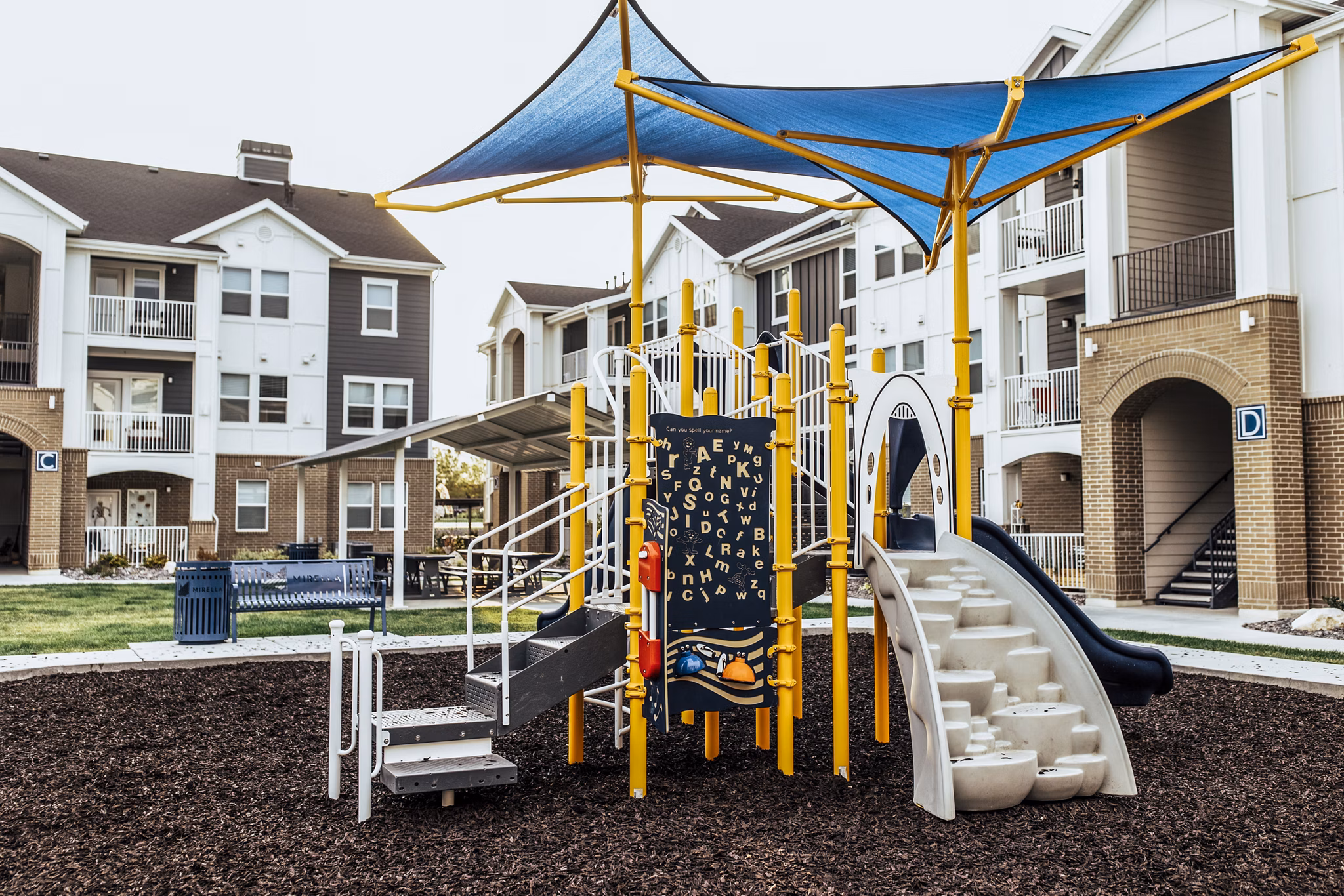 Playground at Mirella at Foxboro Apartments featuring modern play structures for families and residents