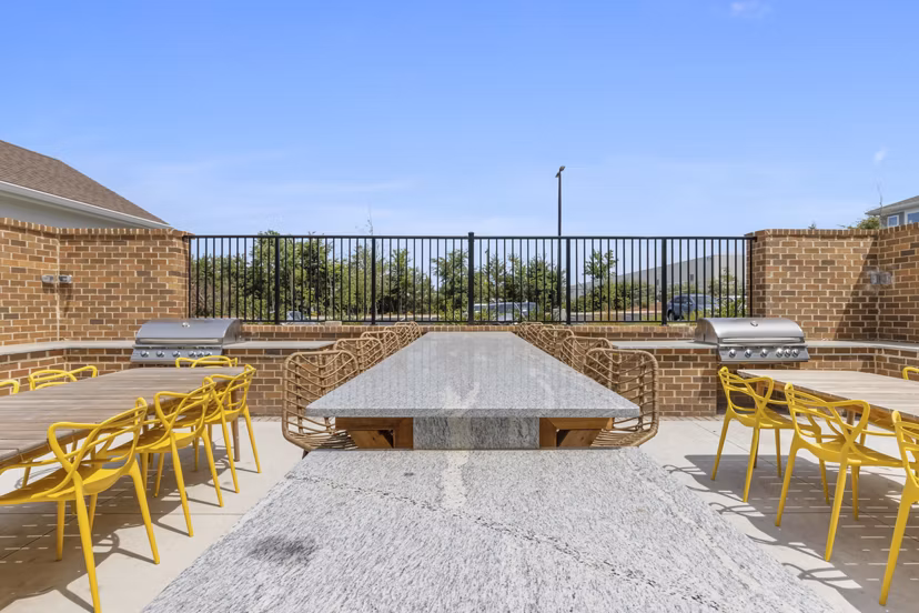 Patio area at Broadstone Ayrsley Apartments featuring modern outdoor seating and lush greenery